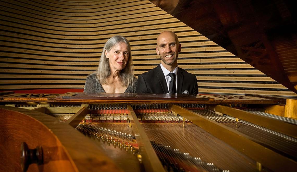 Stephanie McCallum and Erin Helyard sit next to one another with an 1853 Érard piano in front of them. 