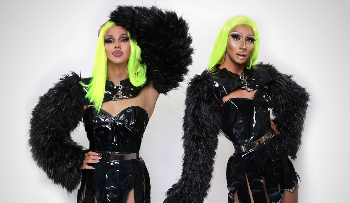 Two drag queens wear neon green wigs and black dresses and collars made of faux patent leather and faux fur/feathers.
