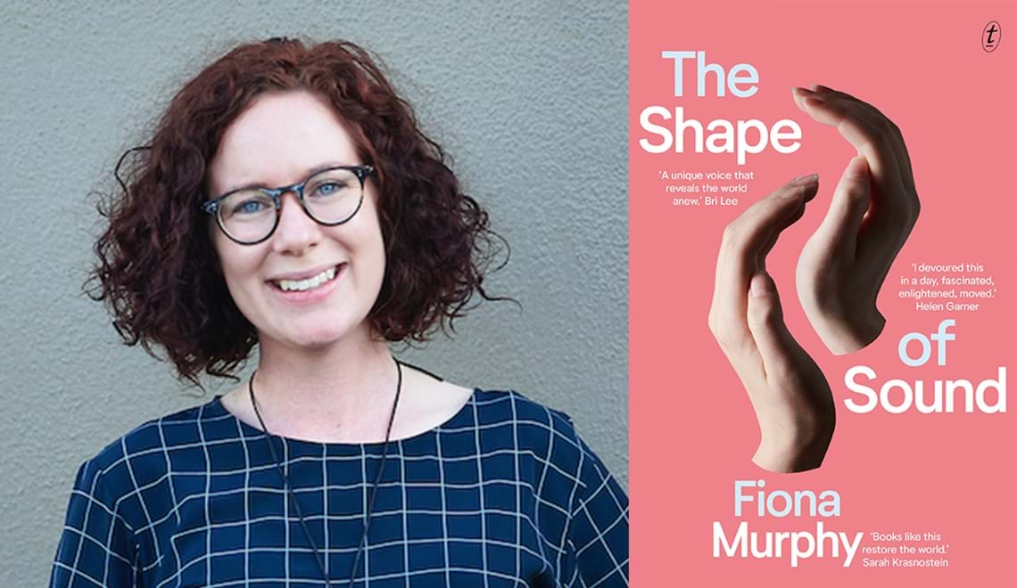 Fiona Murphy is wearing glasses and a dark blue top. She has short, curly dark red hair and is smiling at the camera.