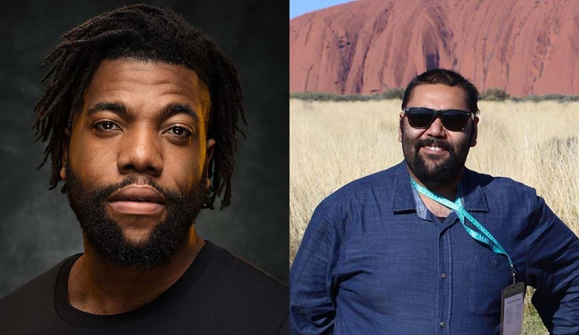 Fehinti Balogun has dark brown, short dreadlocks and a beard; he looks at the camera with a serious expression. Dwayne Coulthard has short, black hair and a beard and is smiling; you can see Uluru in the background behind him.